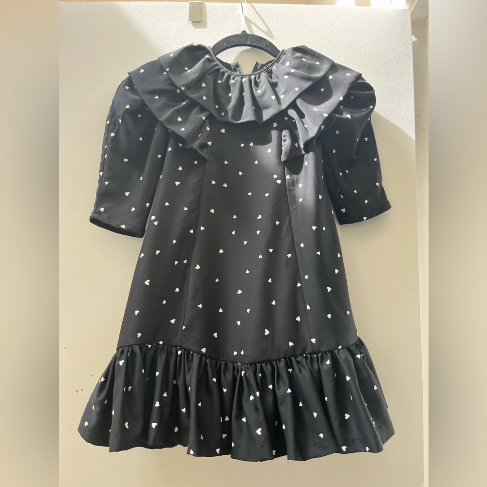 Girls black dress with white hearts and stunning ruffled trims.